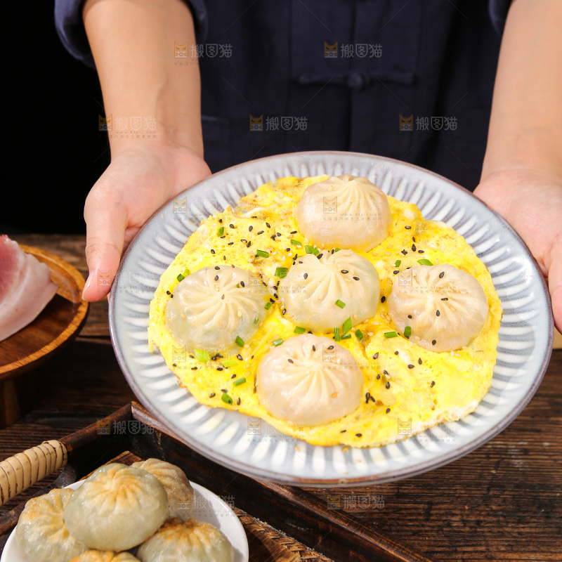 手端着一盘抱蛋煎包