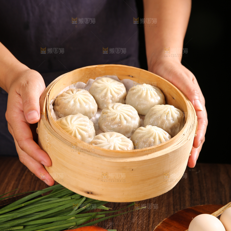 手里端着一笼包子