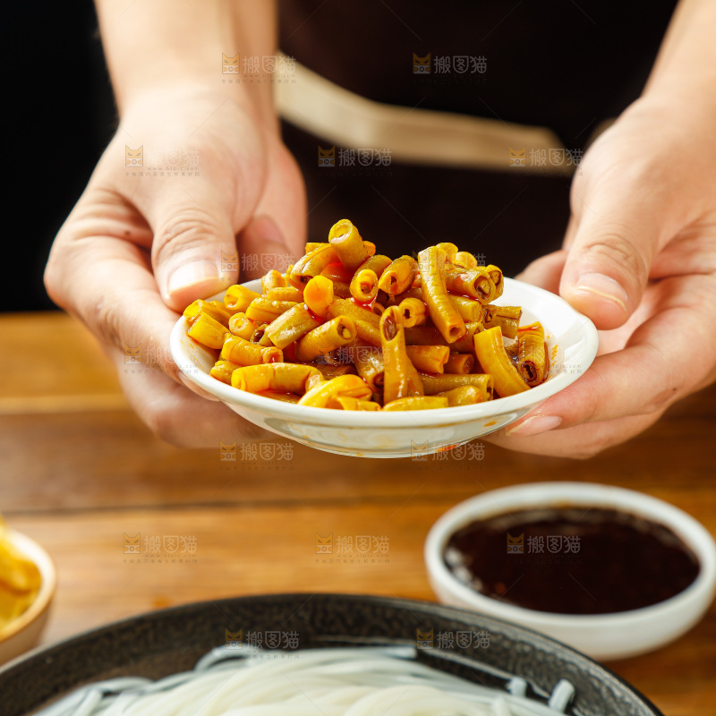 手端着一碟酸豆角