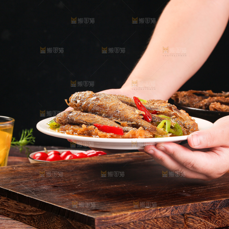 手端着一盘香酥煎鱼