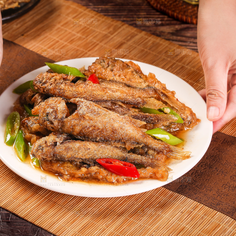 手拿着一盘香酥煎鱼