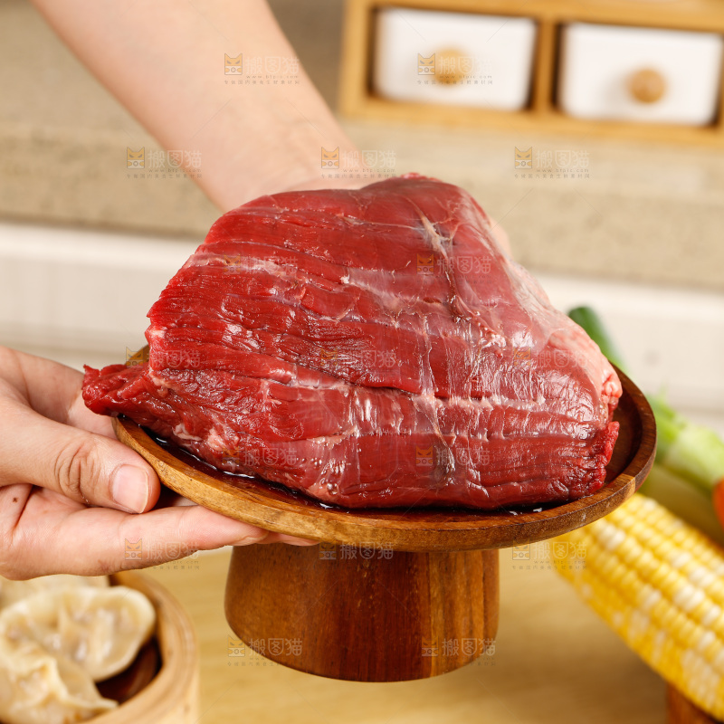 手端着一盘生牛肉