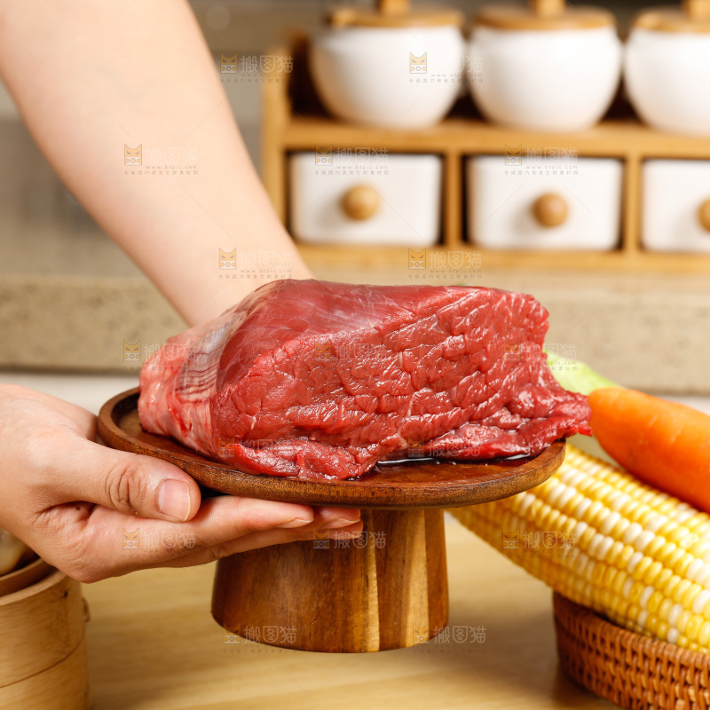 手端着一盘生牛肉