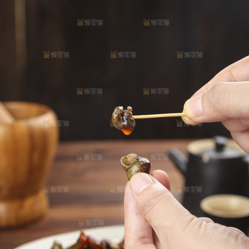 手里拿着牙签挑田螺肉