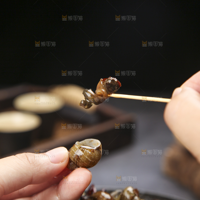 手里拿着牙签挑田螺肉
