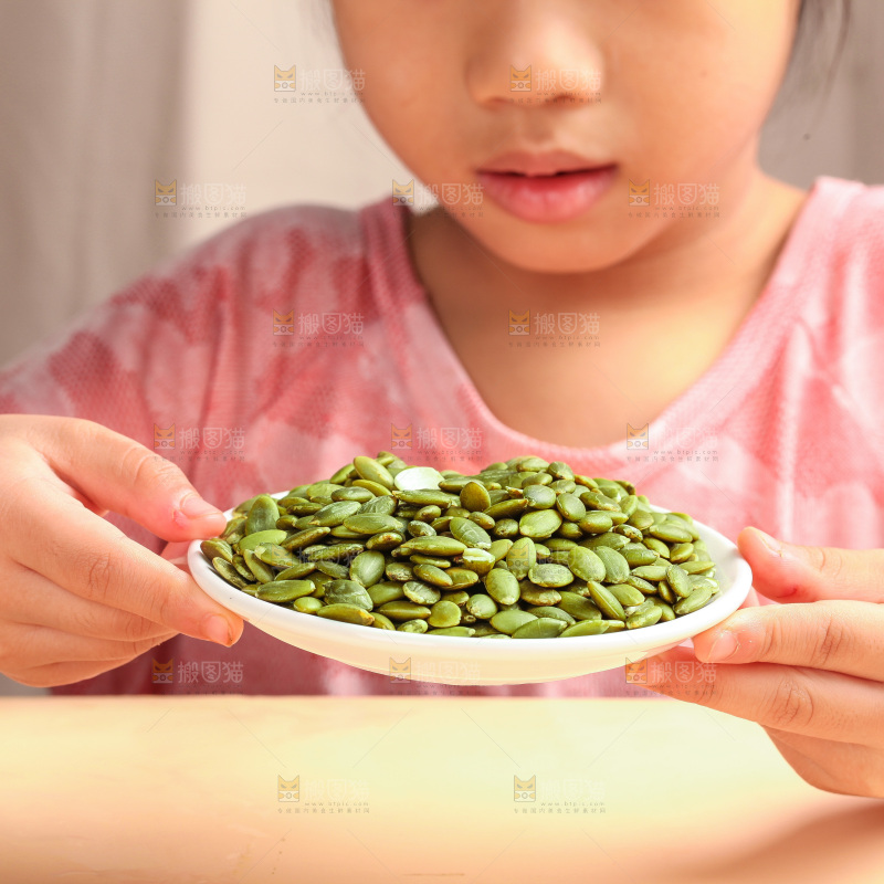 女孩手拿一盘南瓜子仁