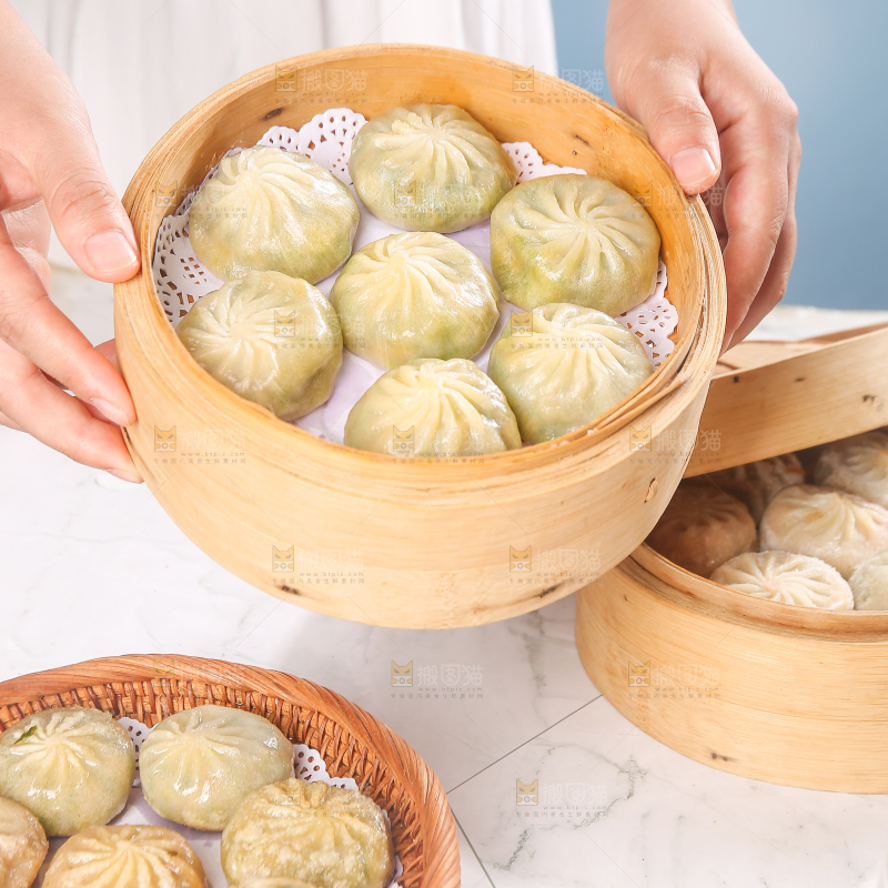 手端着一笼小包子