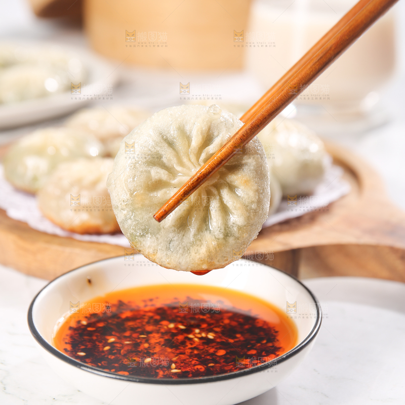 筷子夹着蘸酱的小包子