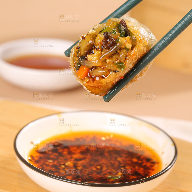 筷子上夹着蘸酱的包子