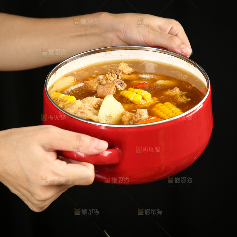 手里端着一碗玉米胡萝卜排骨汤
