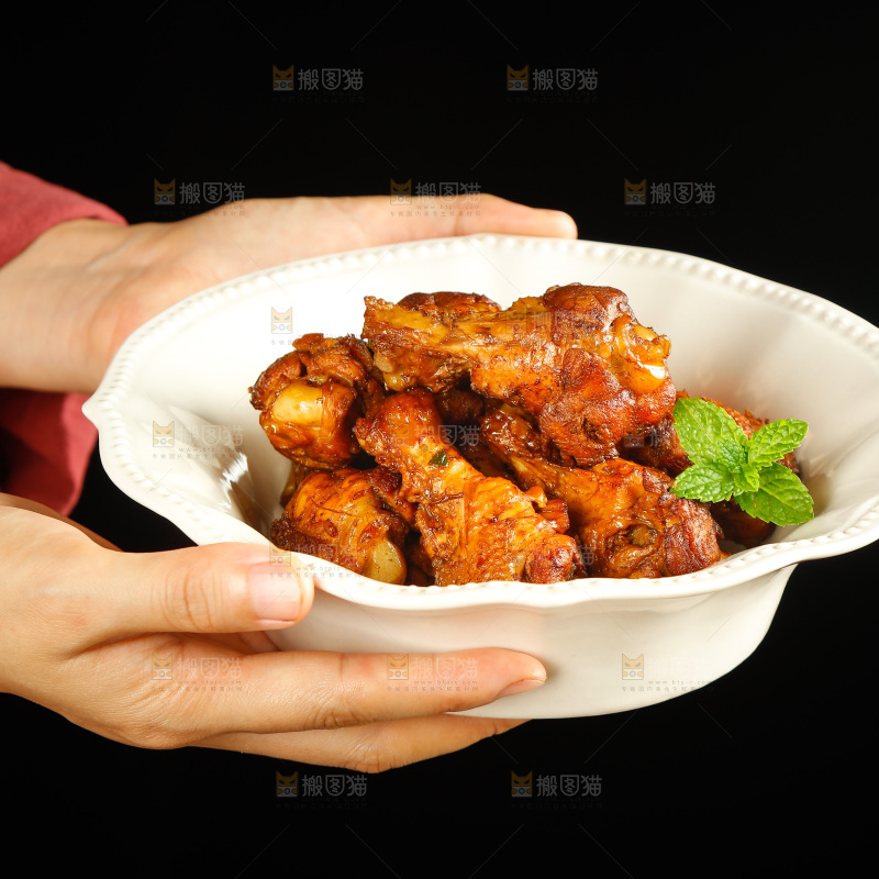 手里端着一盘红烧小鸡腿