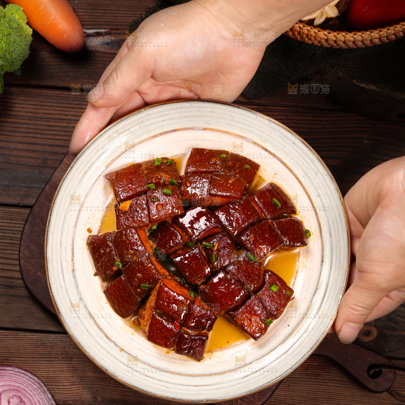 手里端着一盘东坡肉
