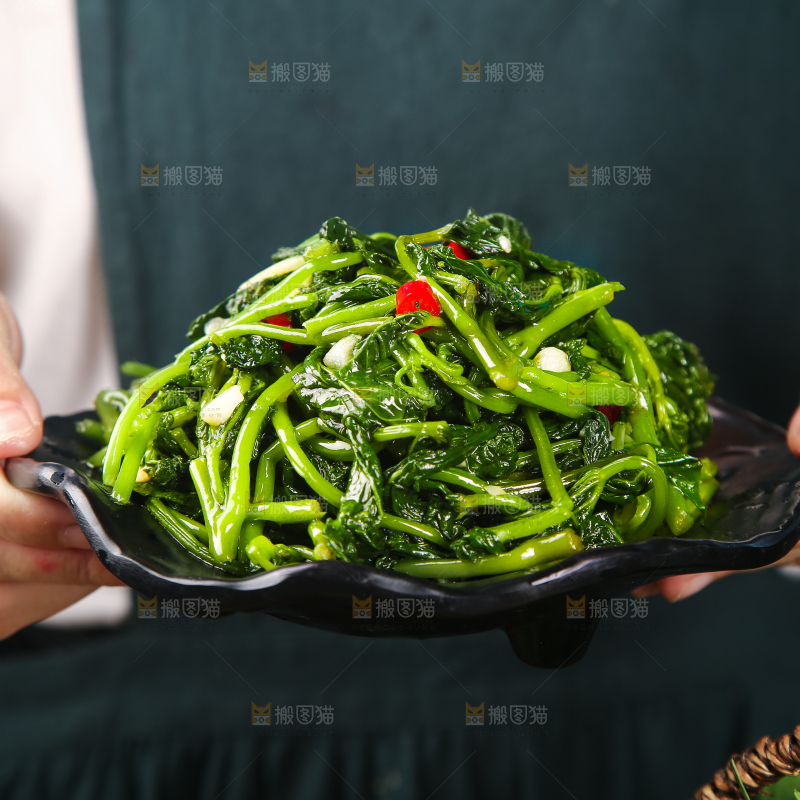 手里端着一盘炝炒苕尖