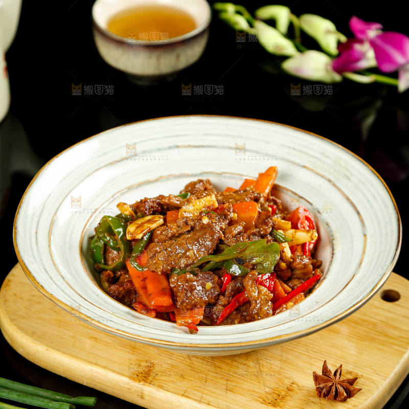 木板上放着一盘青椒烧牛肉
