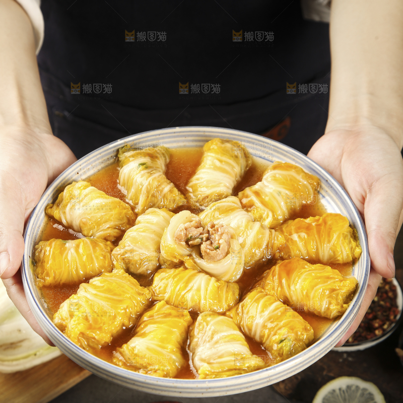 手里端着一盘白菜酿肉卷