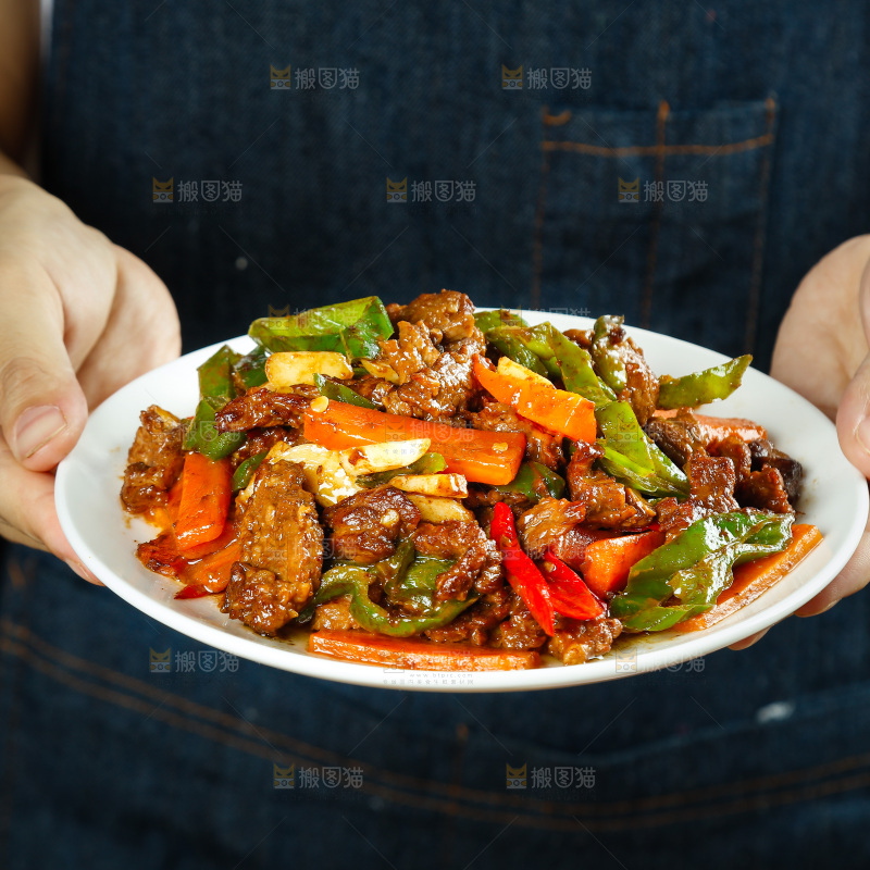 手里端着一盘辣椒炒牛肉