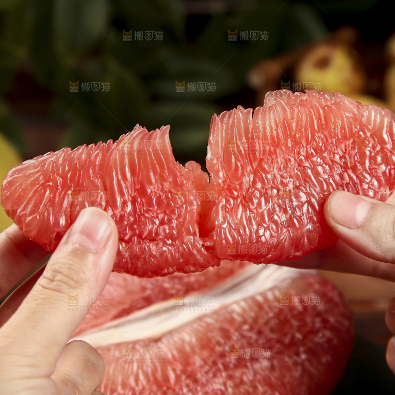 手里拿着红心柚