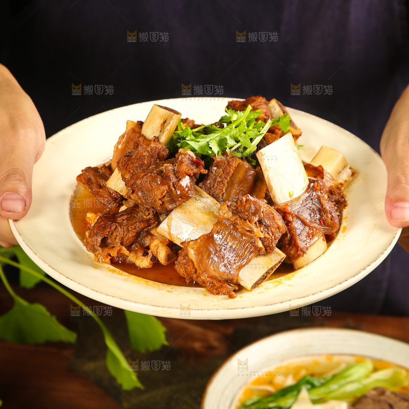 手里端着一盘红烧牛肋排