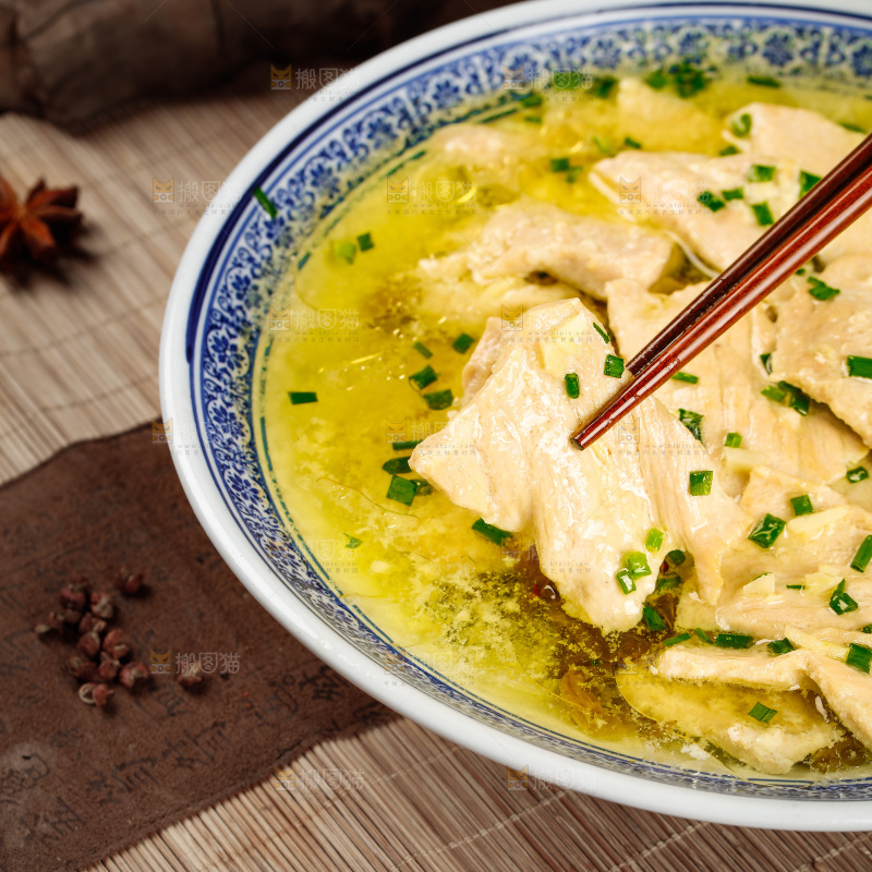 一碗酸汤肉片和筷子上夹着肉片