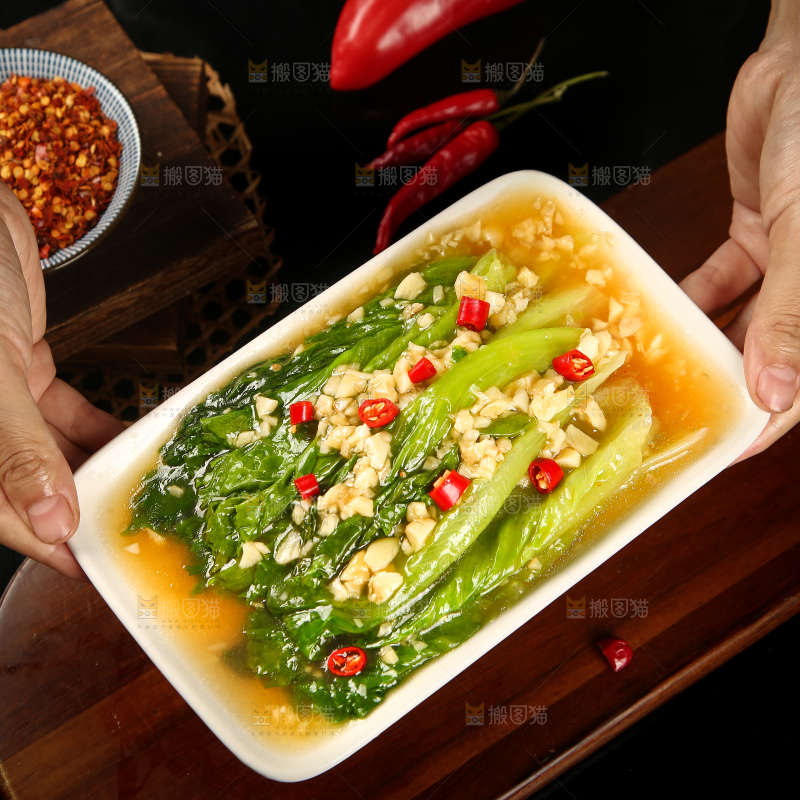 手里端着一盘蒜蓉生菜