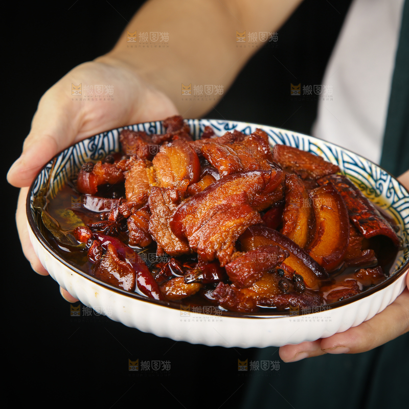 手里端着一盘把子肉