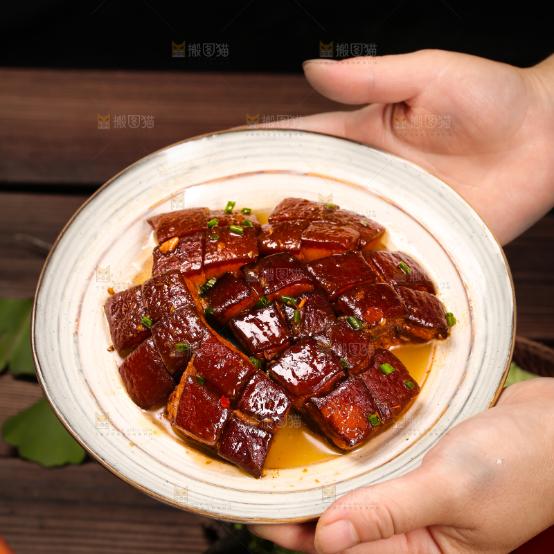 手里端着一盘东坡肉
