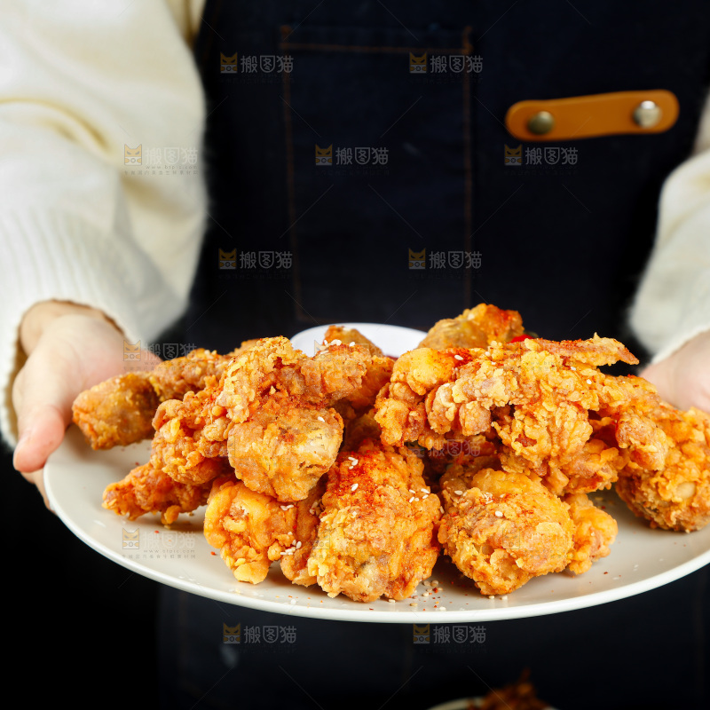 手里端着一盘香酥炸鸡腿
