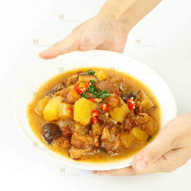 手里端着一盘土豆香菇焖鸡