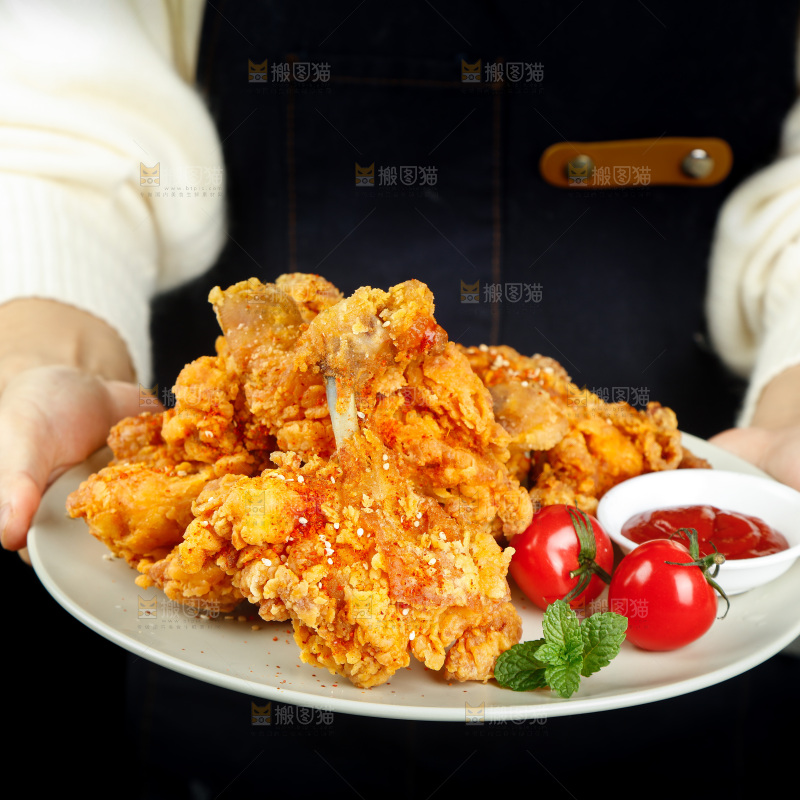 手里端着一盘香酥炸鸡腿