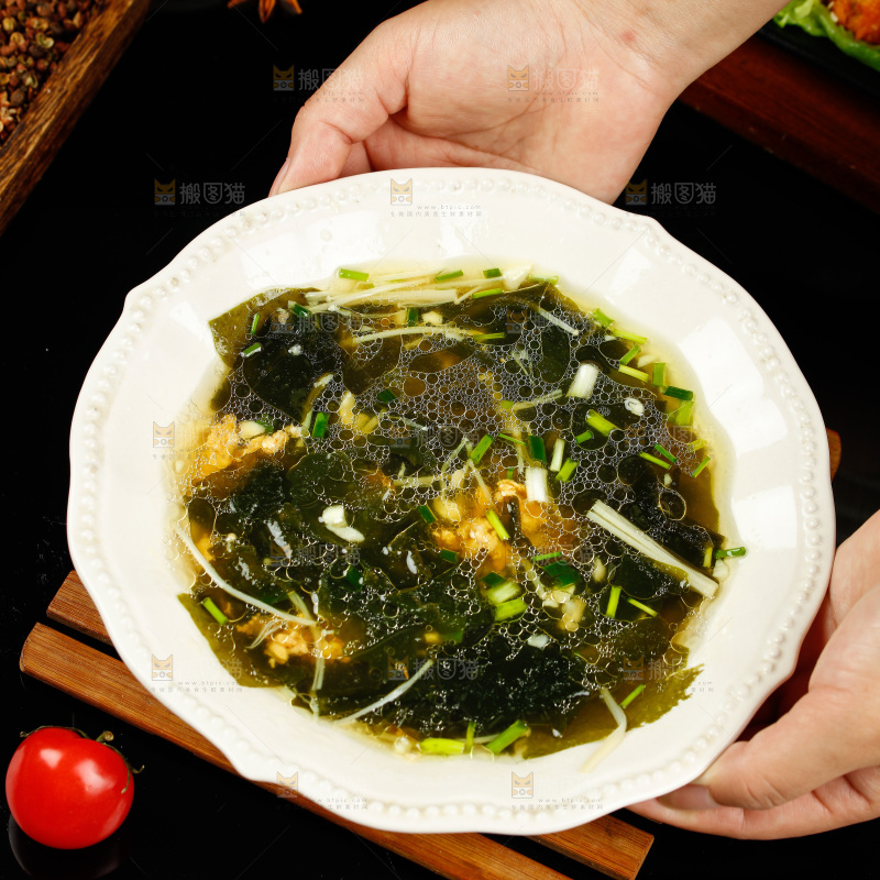 手里端着一盘裙带菜汤