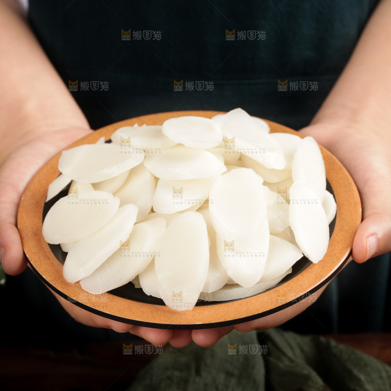 手里端着一盘宁波年糕片