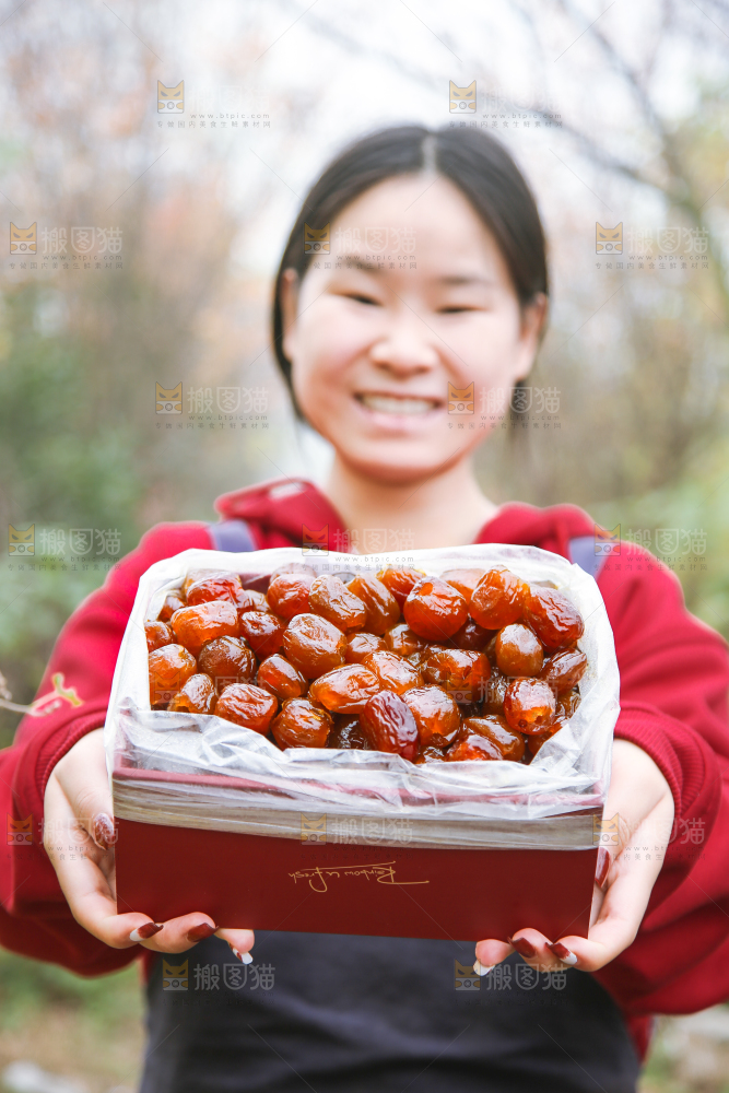 手里拿着一盒蜜枣
