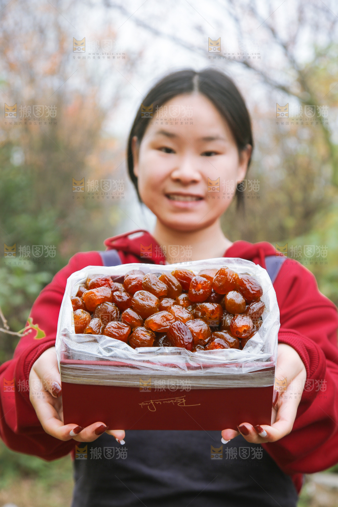 手里拿着一盒蜜枣