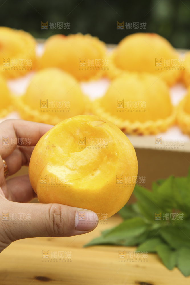 手里拿着黄油桃