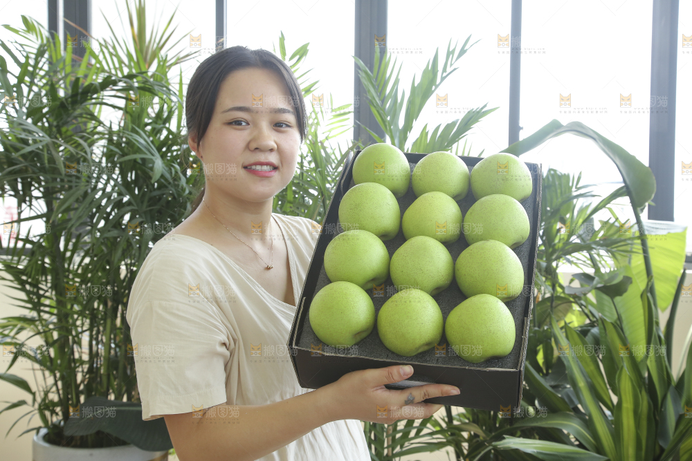手里拿着一盒青皇冠梨