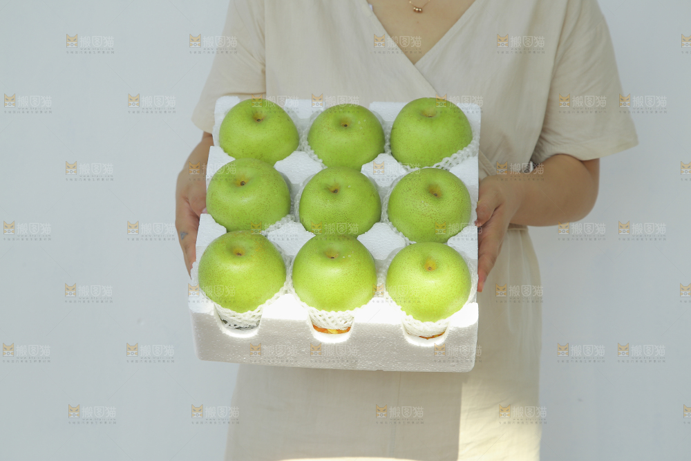 手里拿着一盒青皇冠梨