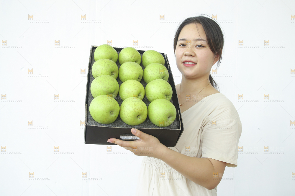 手里拿着一盒青皇冠梨