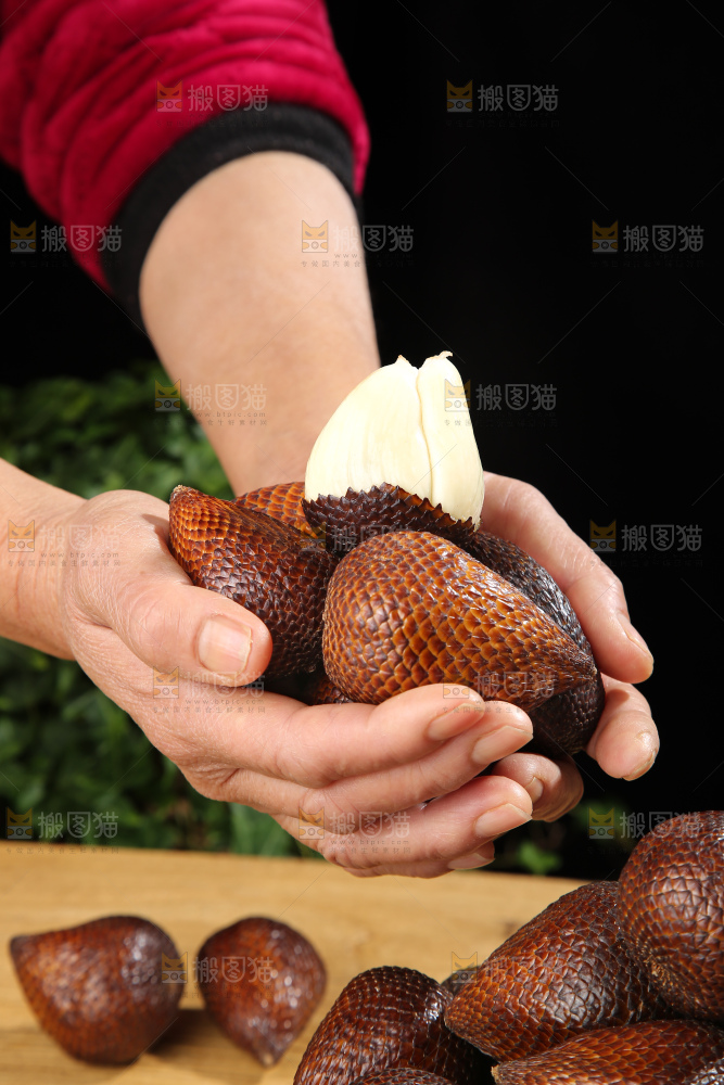 手里拿着蛇皮果