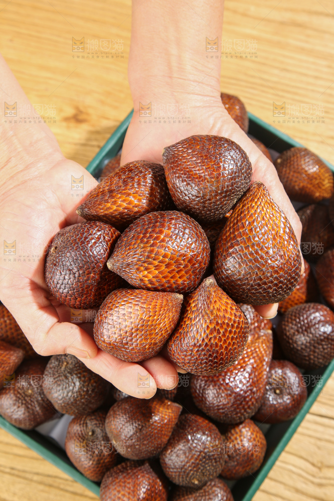 手里拿着蛇皮果