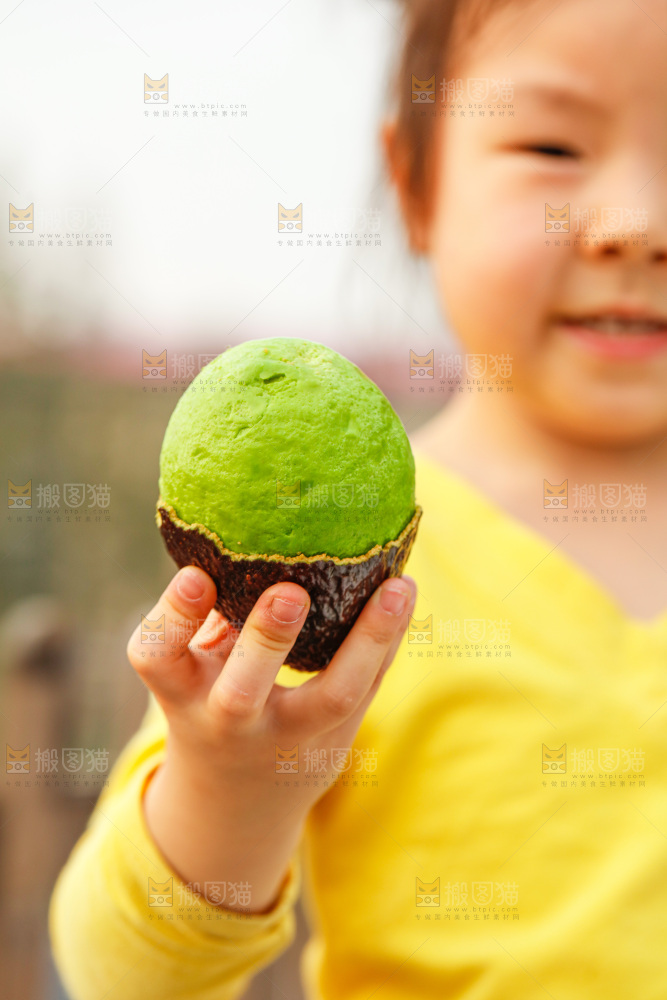 手里拿着巨无霸牛油果