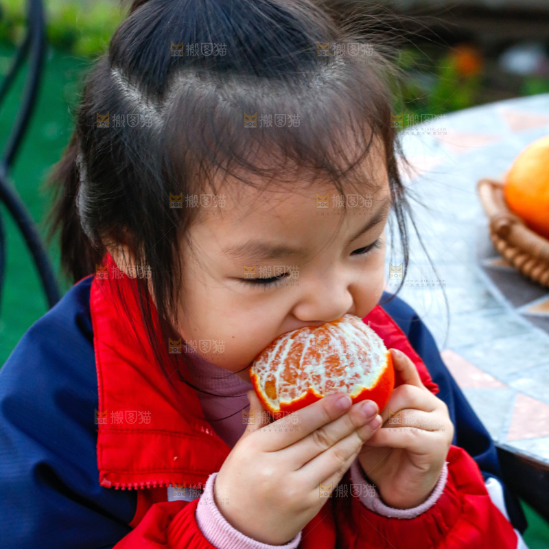 小孩正在吃着蜜桔