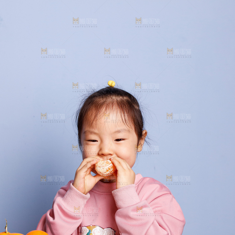 小孩正在吃着蜜桔